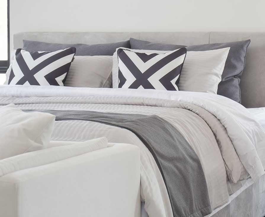Modern Gray tone bedding and bedside table and lamp in black